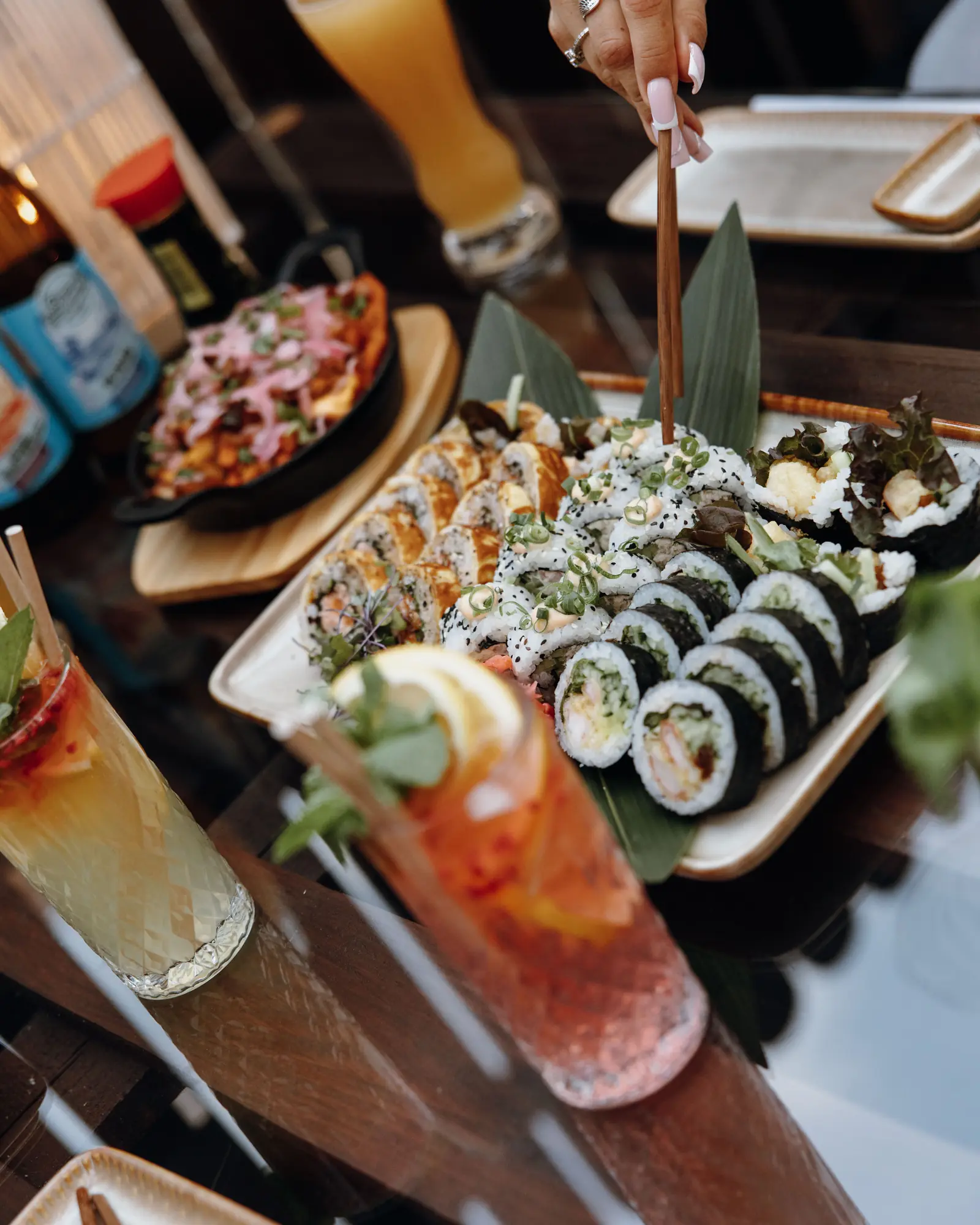 Stół z sushi, koktajlami i daniami kuchni azjatyckiej