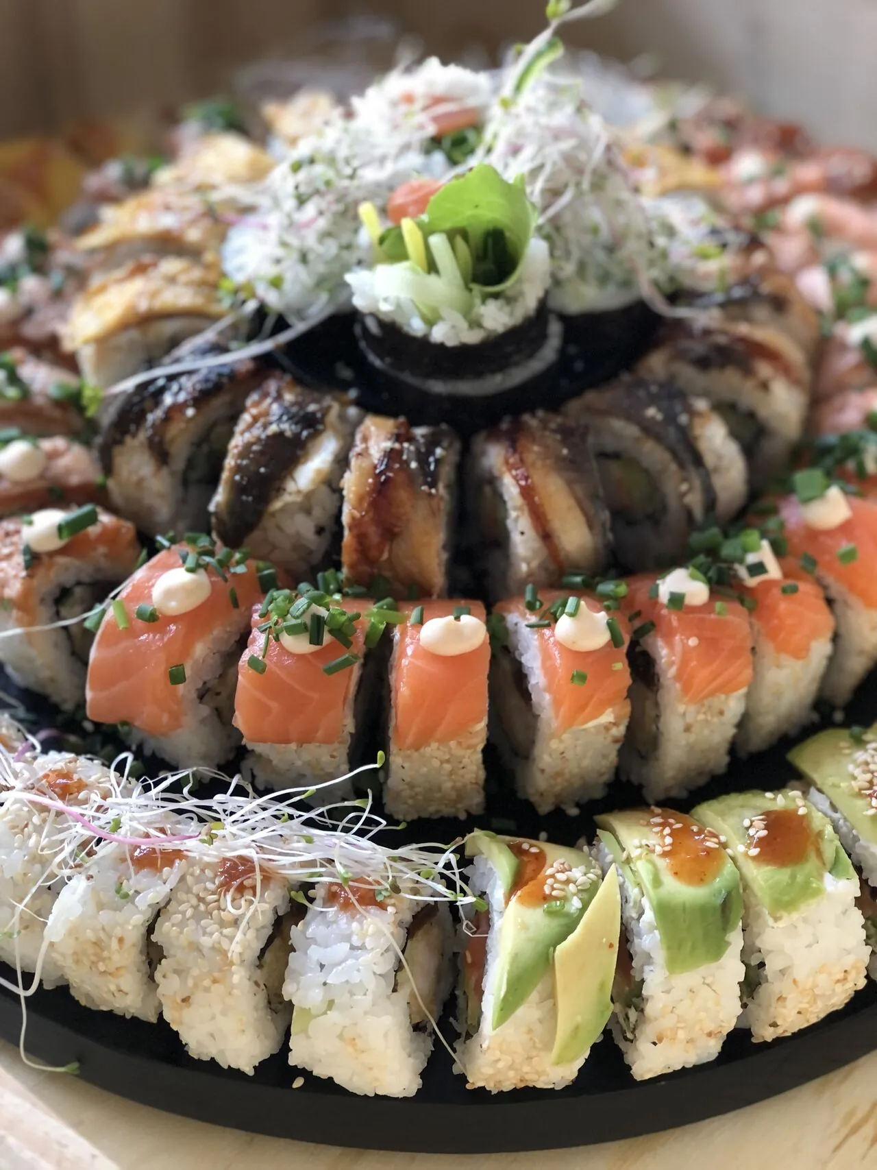 Tort z sushi: rolki z łososiem, węgorzem i awokado ułożone piętrowo